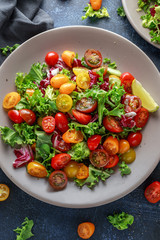 Fresh Cherry Tomato mix salad with lettuce, lemon, lime, black pepper and sea salt. healthy food