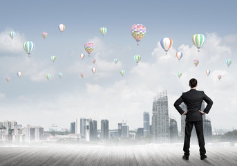 Motivation and inspiration concept with modern cityscape and businessman observing it