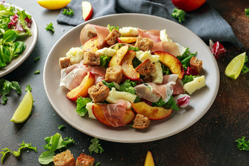 Fresh grilled peach salad with green mix, cheese, prosciutto and crouton