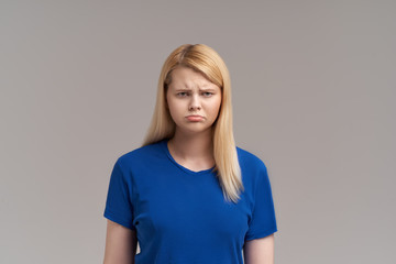 Obraz premium Aggravated brunette female with long straight blonde hair, frowns face in discontent, feels displeasure, being insult by someone