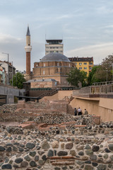Famous landmarks of Sofia, Bulgaria. Ruins of the ancient quarter. Foundations of walls  made of stone and cement. Medieval mosque on the background.