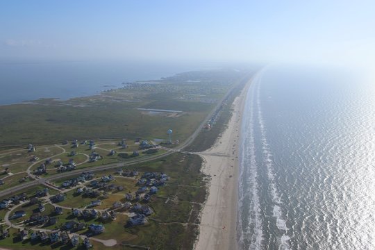 Aerial image of  the Texas Gulf Coast, Galveston Island, United States of America. Haze due to warm weather conditions. Ocean, Gulf of Mexico, beach, real estate and travel landscape panorama.