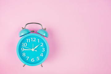 Alarm clock on pink background.