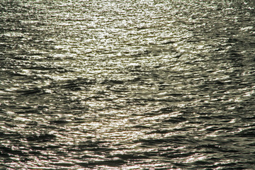 Water waves  and sunrays reflections in river background in the evening