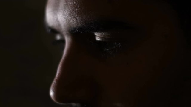 Depressed sad man's eyes in the dark- close up