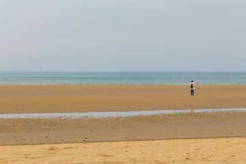 Fototapeta na wymiar Woman walking on the beach landscape
