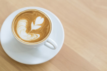 Closeup top view glass of latte art coffee tulip shape on wood background with vintage color, selective focus