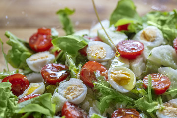 Salad with lettuce, cherry tomatoes, cucumber and quail eggs