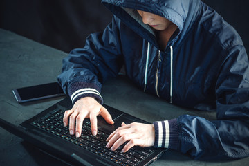 Hacker teen programmer uses a laptop to hack the system. Stealing personal data and infection of...