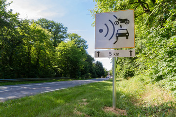 Speed limit speed camera sign close to the road