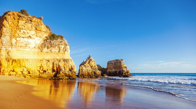 Algarve, Portugal, a stunning sea ocean landscape with yellow rocks and azure water. The beauty of nature and the power of the ocean
