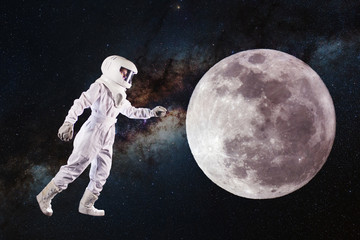 Fototapeta na wymiar Astronaut in space and moon exploration. Concept, astronaut pulls his hand to the lunar surface