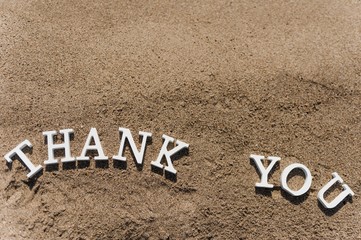 thank you word drawn on the beach sand