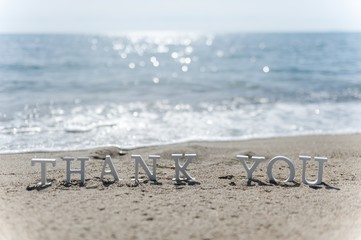 thank you word drawn on the beach sand - 209550343