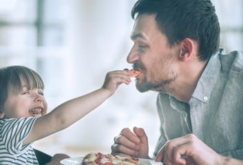 Dad and daughter eat pizza