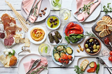  Mediterrane hapjes tafelconcept. Eettafel met tapasselectie: vleeswaren en salami, gazpachosoep, jamon, olijven, kaas, hummus en groenten. Bovenaanzicht. © losangela