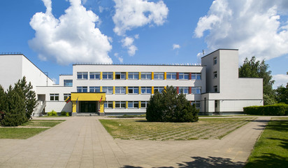Public school building. Exterior view of school building with playground. - obrazy, fototapety, plakaty