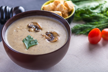 Mushroom cream soup in a brown plate on the table. Healthy autumn vegetarian traditional dish