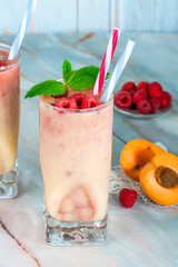 Peach and raspberry melba smoothie garnished with fresh fruit and mint