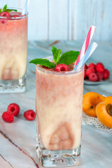 Peach and raspberry melba smoothie garnished with fresh fruit and mint