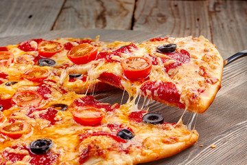 Lifted pepperoni pizza slice with melted cheese