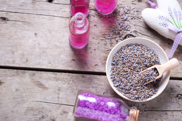 Obraz na płótnie Canvas Dry lavender buds bowl, sachet wit lavender and bottles with cosmetics
