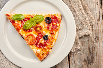Slice of pepperoni pizza on dish