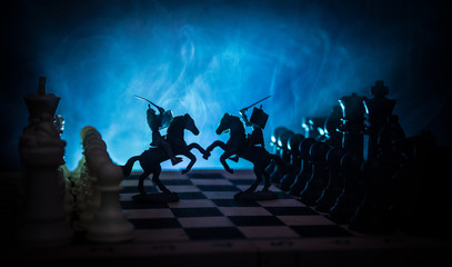 Medieval battle scene with cavalry and infantry on chessboard. Chess board game concept of business ideas and competition and strategy ideas Chess figures on a dark background