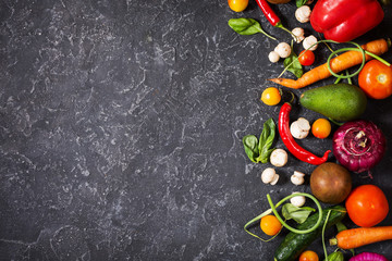 Raw organic vegetables with fresh ingredients for healthily cooking on vintage background, top view. Vegan or diet food concept