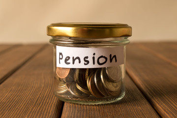 Different coins in glass jar. The concept of pension savings