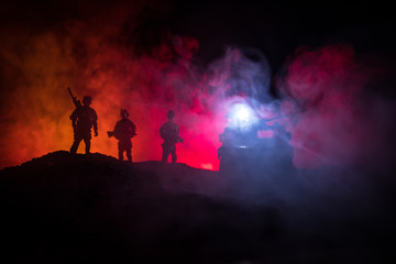Naklejka na ściany i meble War Concept. Military silhouettes fighting scene on war fog sky background, World War Soldiers Silhouettes Below Cloudy Skyline At night. Attack scene. Army jeep vehicles with soldiers. army jeep