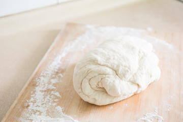 Raw dough and flour on wooden table