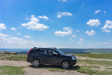 Fototapeta premium Black SUV on top of White Rock mountain.