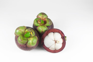 Isolated mangosteens. Two whole fruits and one half isolated on white background with clipping path