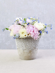 Floral arrangement with pink peonies, ranunculus flowers, white chrysanthemums, matricaria forget me not and bluebells (muscari).