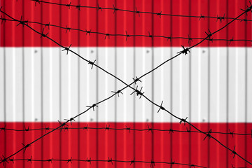 National flag of Austria on fence. Barbed wire in the foreground symbolizes entry ban or prohibition for crossing border of country