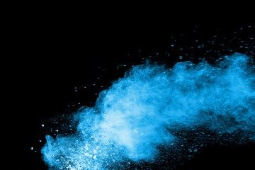 Abstract blue dust explosion on  black background.  Freeze motion of blue powder splash. Painted Holi in festival
