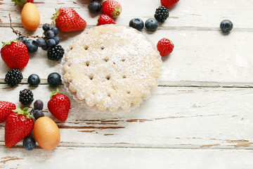 Blueberry pie and fruits on wooden table.
