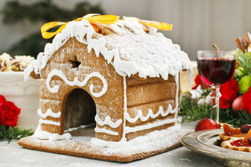Gingerbread house decorated with icing on Christmas eve table