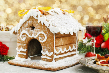 Gingerbread house decorated with icing on Christmas eve table