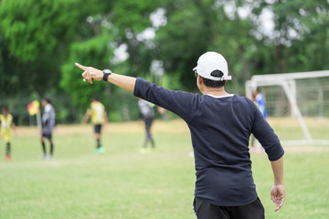 Football or socker coach observing kid football match.Healthy sport concept.