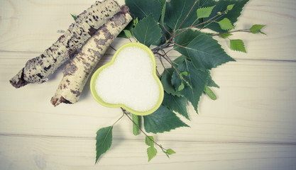 Xylitol - sugar substitute. Birch sugar on white wooden background.