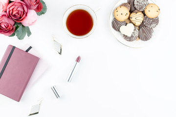 Flat lay home office desk. Feminine workspace with diary, flowers, sweets, fashion accessories. Fashion blogger concept.