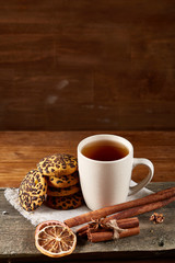 Cup of tea and chocolate chip cookies on white homespun napkin in country style, selective focus.