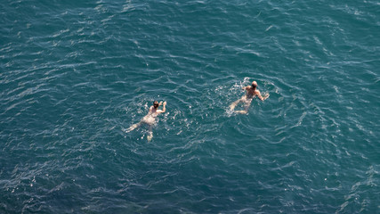 Un uomo ed una donna che nuotano in un mare bellissimo