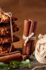 Christmas composition with oatmeal, chocolate biscuits, and spices, on wooden background, close-up, selective focus.