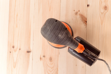 top view of the orbital sander on a wooden table