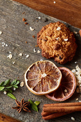Christmas composition with oatmeal, chocolate biscuits, and spices, on wooden background, close-up, selective focus.
