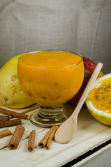 Healthy dessert made with passion fruit, mango and cinnamon, served in a glass bowl