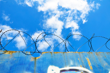 barbed wire fence against blue sky, prison, ban